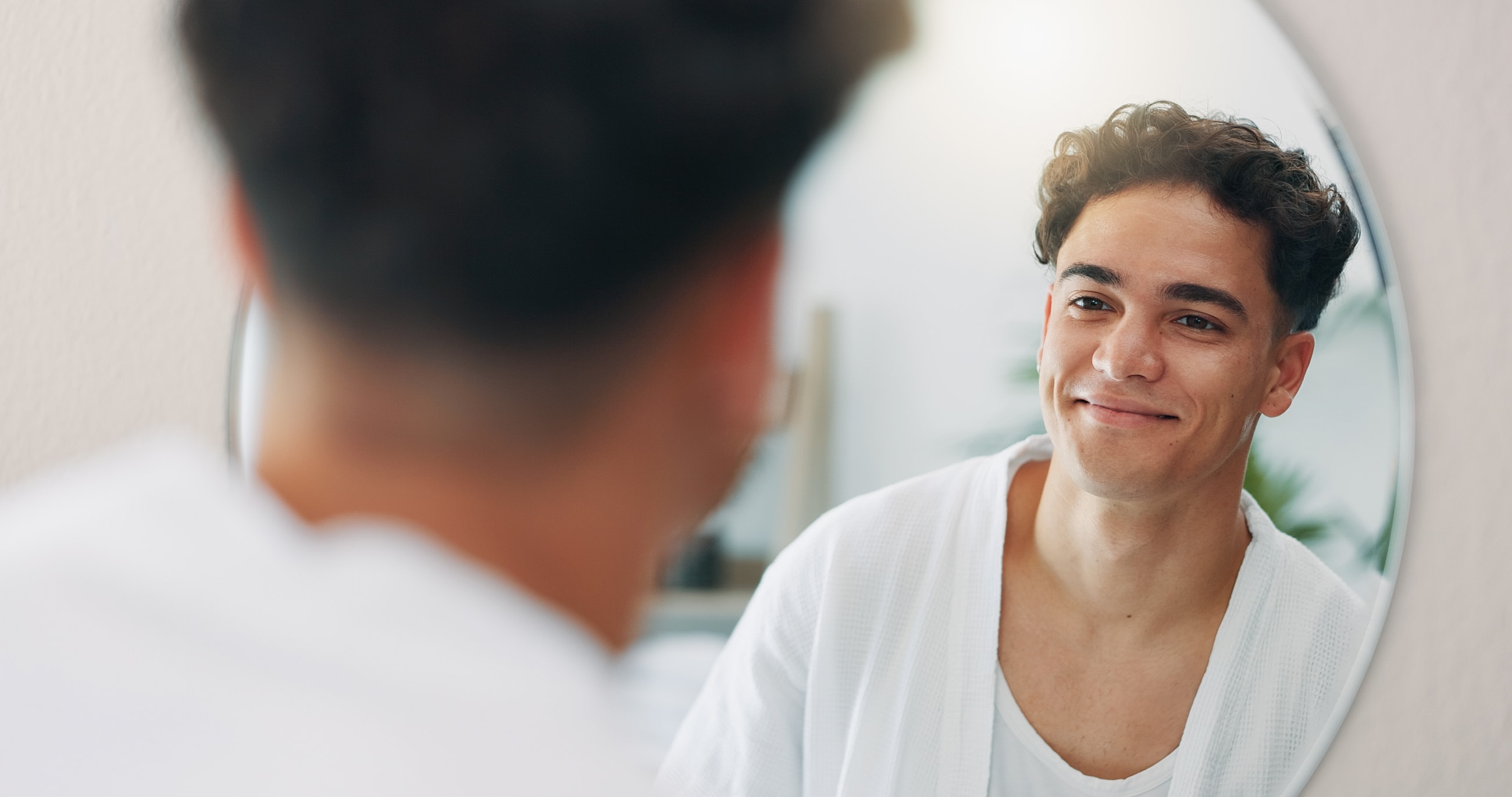Pittsburgh Male Facelift model looking into mirror at home.
