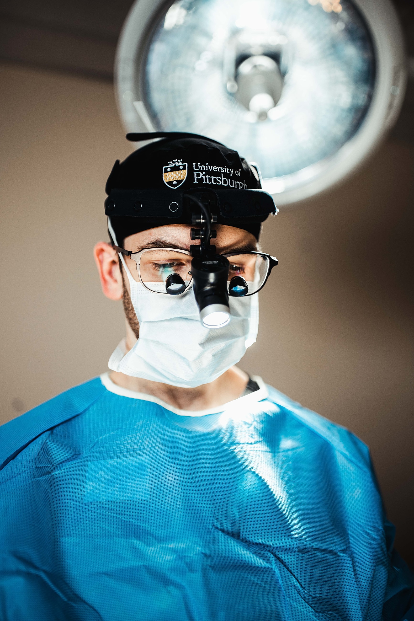 Surgeon wearing protective gear and headlamp.
