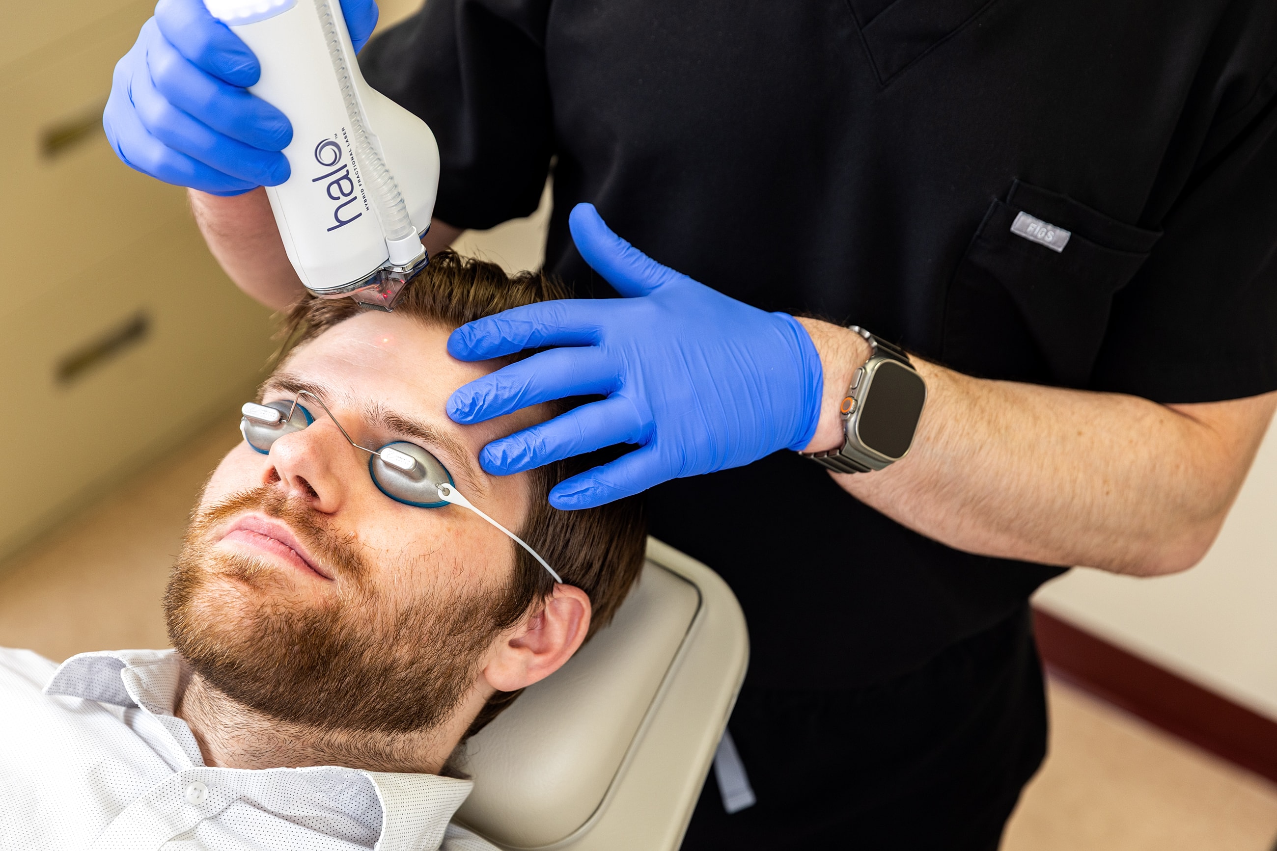 Patient receiving laser treatment on forehead.